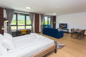 a bedroom with a large white bed and a living room at Complex Gallery Vitosha **** in Sofia