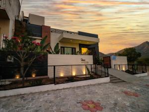 Lavanya Villa with private pool Udaipur في أودايبور: منزل مع غروب الشمس في الخلفية