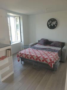 1 dormitorio con 1 cama con edredón rojo y blanco en appartement meublé parking gratuit 2 nuits minimum, en Montaigu-Vendée