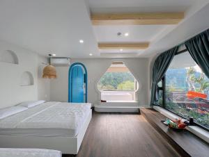 a bedroom with a large bed and large windows at Sunmay Villa Tam Dao - Venuestay in Vĩnh Phúc