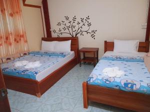 um quarto com 2 camas, uma mesa e cadeiras em โฮมสเตย์ยายสฤษดิ์ (ซอย 17 ล่าง) em Chiang Khan