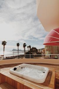 a bath tub sitting on the deck of a house at Rose Thé in La Ciotat