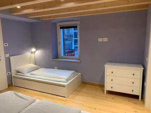1 dormitorio con cama y ventana en Albergo Stella, en Cavalese