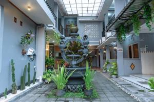 a fountain in the middle of a building with plants at Metro Malioboro Living in Yogyakarta