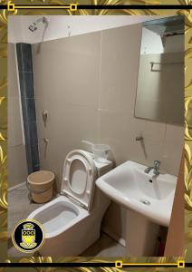 La petite salle de bains est pourvue de toilettes et d'un lavabo. dans l'établissement White Knights Real, à Dumaguete