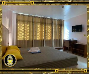 um quarto com uma cama grande e um cobertor amarelo em White Knights Real em Dumaguete