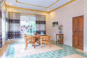 a dining room with a table and chairs and a window at Metro Malioboro Living in Yogyakarta