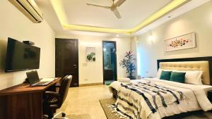 a bedroom with a bed and a desk with a laptop at BluO Park Facing 3BHK- Lift, Balcony, Parking in New Delhi
