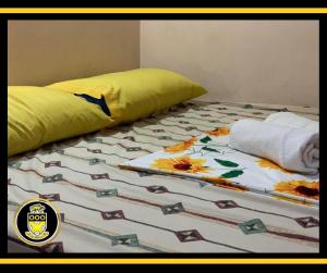 a bed with a comforter and a pillow on it at White Knights Dumaguete in Dumaguete