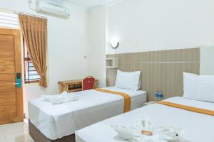 a hotel room with two beds and a window at Metro Malioboro Living in Yogyakarta