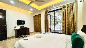 a bedroom with a bed and a window and a desk at BluO Park Facing 3BHK- Lift, Balcony, Parking in New Delhi +4 photos