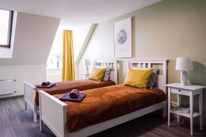 een slaapkamer met 2 bedden en gele kussens bij Rothko apartment/8 guests/4bedrooms/Riga Old Town in Rīga