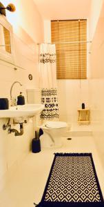 a white bathroom with a sink and a toilet at HOKKUM STUDIOS in Kokkari