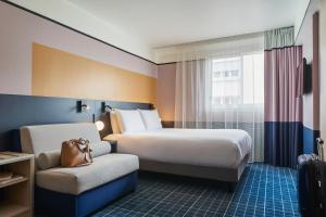 a hotel room with a bed and a chair at Mercure Paris 15 Porte de Versailles in Paris +89 photos