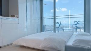 a bedroom with a white bed and a large window at Shine residence in Incheon