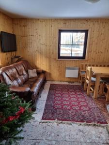 ein Wohnzimmer mit einem Ledersofa und einem Tisch in der Unterkunft Chata Pod Velkou Racou in Oščadnica