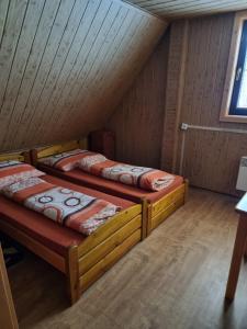 two beds in a room with a attic at Chata Pod Velkou Racou in Oščadnica