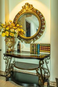 a table with a mirror and a vase of flowers and books at Cao Gia Hải in Ho Chi Minh City