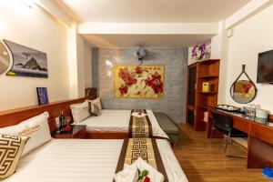 a hotel room with two beds and a desk at Cao Gia Hải in Ho Chi Minh City