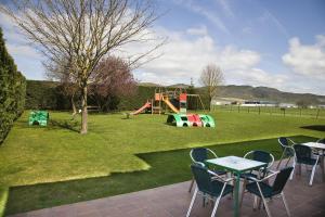 un parque con parque infantil con mesas y sillas en Hotel Ekai, en Ecay