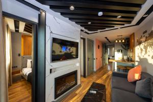 Una sala de estar con chimenea y televisión. en Roe Suite Hotel - TAKSIM, en Estambul