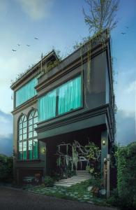 バンコクにあるThe Black Kingdom - เดอะ แบล็ค คิงดอมの緑のカーテンが付いた大きな建物