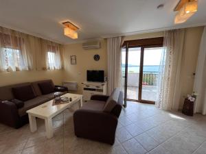 a living room with a couch and a table and a tv at Cosy Apartment with Sea view in Santa Marina in Sozopol