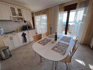 a kitchen with a white table with a bottle of wine at Cosy Apartment with Sea view in Santa Marina in Sozopol