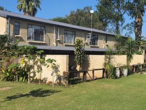 a house with a fence in front of it at KatiKati Eco Lodge in White River