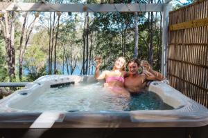 Ein Mann und eine Frau sitzen in einem Whirlpool in der Unterkunft Donnelly Lakes in Pemberton