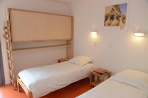 duas camas num pequeno quarto com em LA FONTAINE D'ANNIBAL em Buis-les-Baronnies