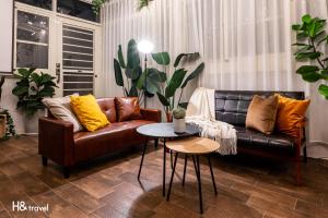 a living room with a leather couch and a table at Penghu Storyteller in Magong