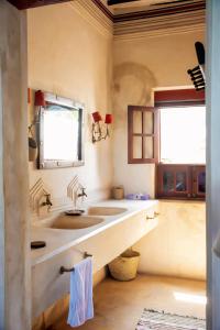 a bathroom with two sinks and two windows at LAMU HOUSE in Lamu