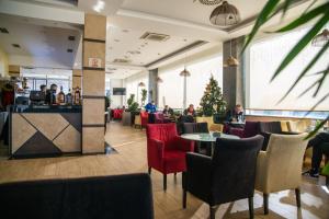 un restaurant avec des chaises rouges et un sapin de Noël dans l'établissement Motel Celebic, à Podgorica