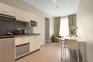 a kitchen with a table and a dining room at Hôtel Spa Thermalia in Châtel-Guyon