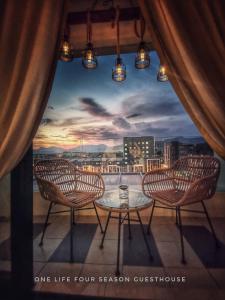 a balcony with two chairs and a table with a view at One Life Four Season Waterpark Guest House Manhattan Condominium in Ipoh