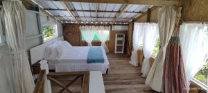 um quarto com uma cama branca num quarto com janelas em Hotel YELLOW HOME Providencia Isla em Providencia