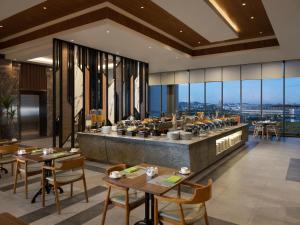 an image of a restaurant with tables and chairs at Hotel Santika Batam in Batam Center