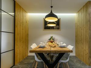 a dining room with a wooden table and white chairs at VisitZakopane - Modrzejewska Apartments in Zakopane