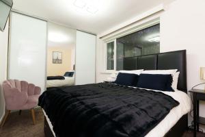 1 dormitorio con 1 cama negra grande y 1 silla en West Park House, en Bramhope