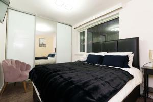 a bedroom with a large black bed and a chair at West Park House in Bramhope