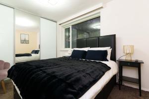 a bedroom with a large black bed and a window at West Park House in Bramhope