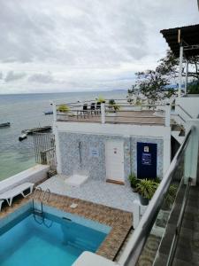 a house with a swimming pool next to the ocean at Germaroze in Oslob