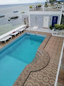 a swimming pool with a view of the ocean at Germaroze in Oslob