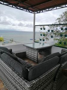 a patio with a table and chairs and the ocean at Germaroze in Oslob