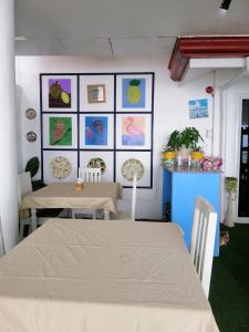 uma sala de jantar com duas mesas e quadros na parede em Germaroze em Oslob