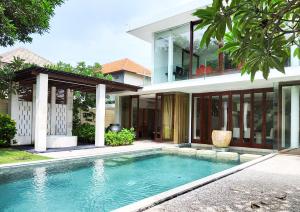 a house with a swimming pool in front of a house at The Wangsa Hotel and Villas Benoa in Nusa Dua