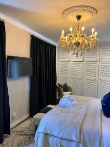 een slaapkamer met een groot bed en een kroonluchter bij Smithgrove Guesthouse in Pietermaritzburg