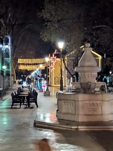 a fountain in the middle of a street at night at Cozy place in Trebinje