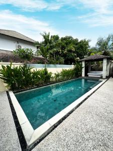 a swimming pool in front of a house at The Wangsa Benoa in Nusa Dua